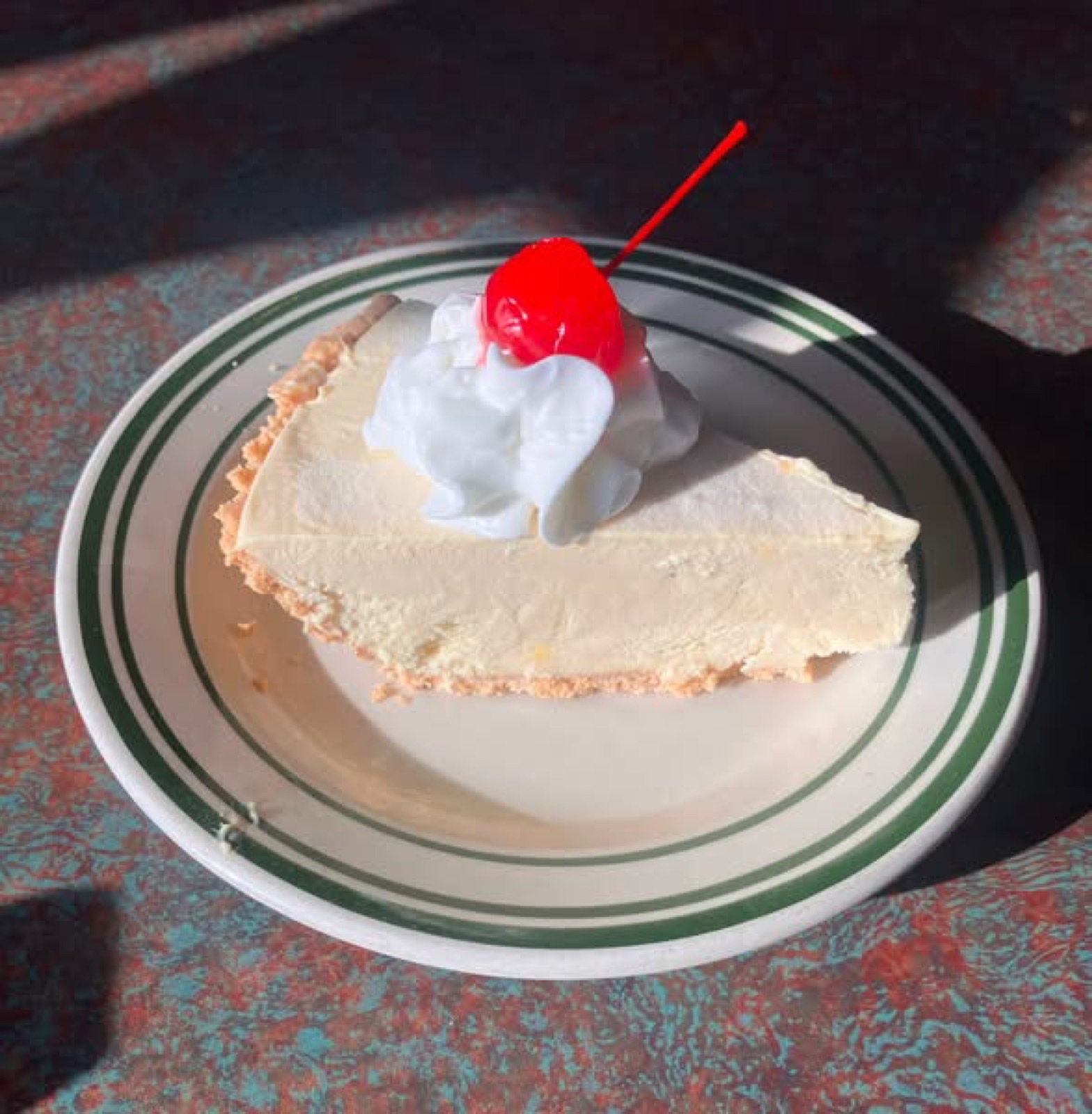 Slice of Sundrop cake with whipped cream and cherry