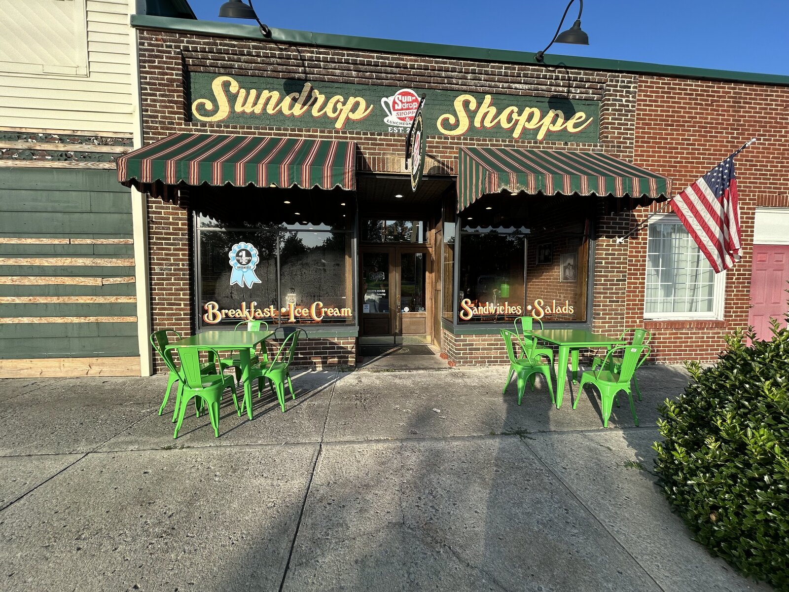Sundrop Shoppe storefront with striped awnings and outdoor seating