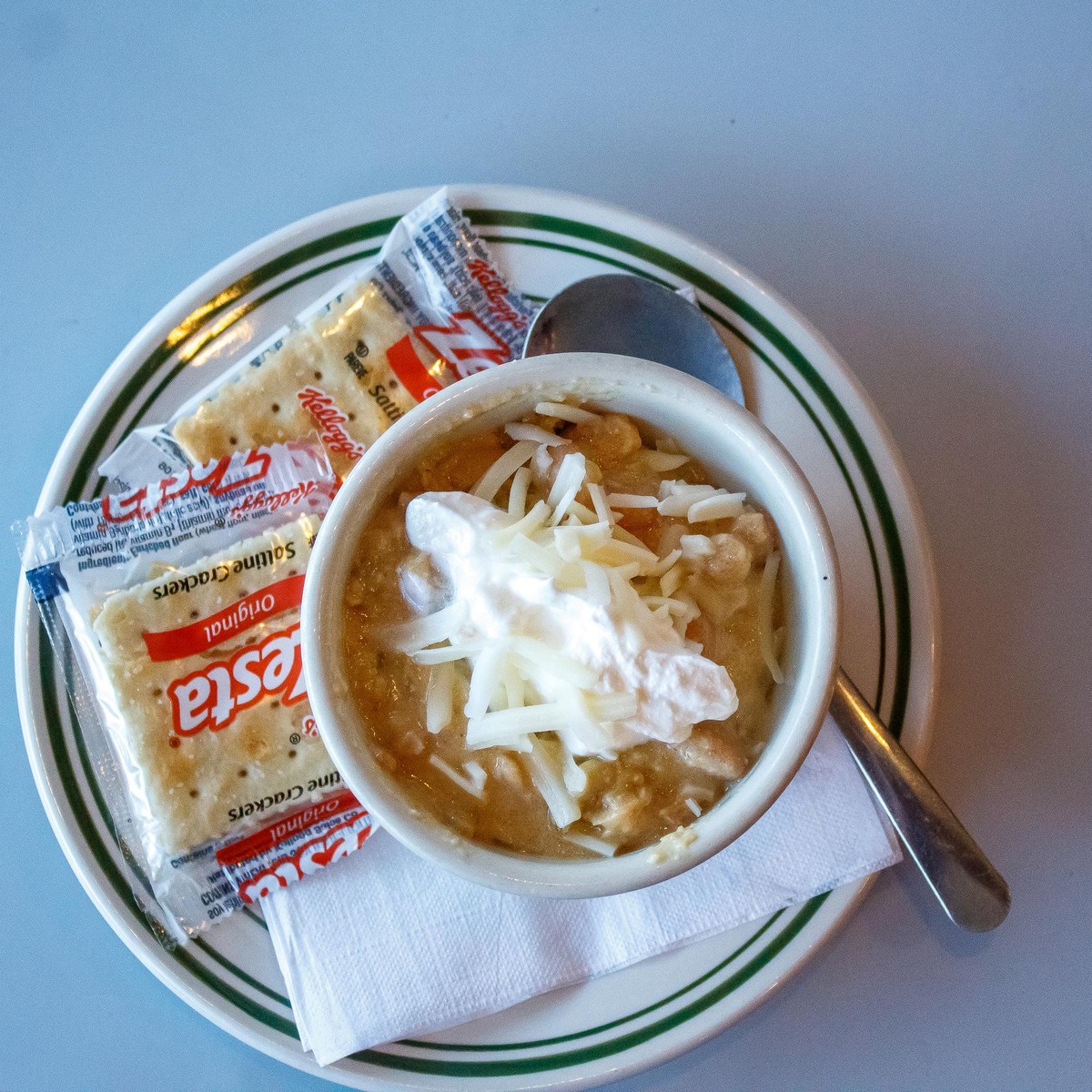 White chicken chili topped with cheese and bacon